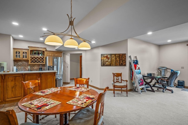 dining space with indoor wet bar, recessed lighting, light colored carpet, and baseboards