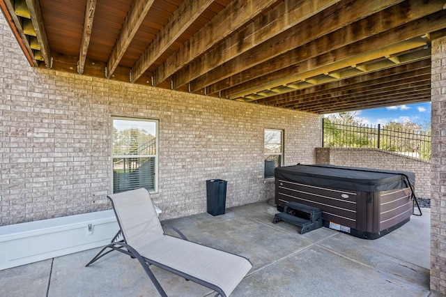 view of patio featuring fence and a hot tub