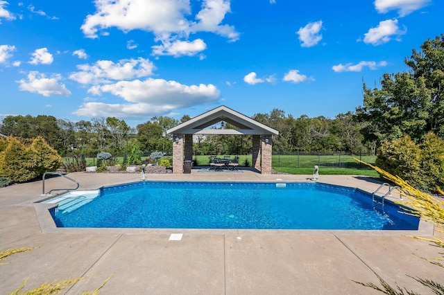 view of swimming pool featuring a patio area, fence, a fenced in pool, and a gazebo