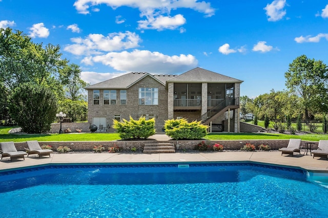 outdoor pool with fence, a sunroom, a lawn, stairway, and a patio area