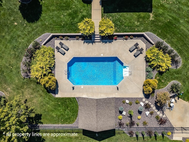 view of swimming pool featuring fence and a lawn