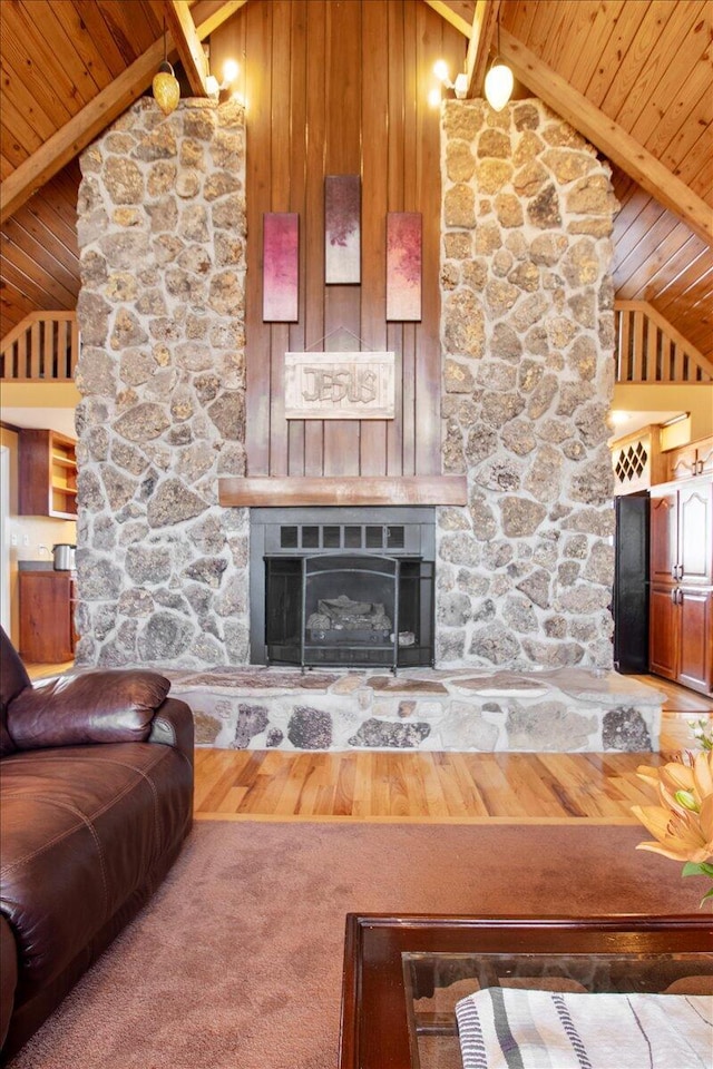 living room with a stone fireplace, wooden ceiling, lofted ceiling with beams, and wood finished floors