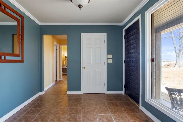 tiled foyer entrance with crown molding and baseboards