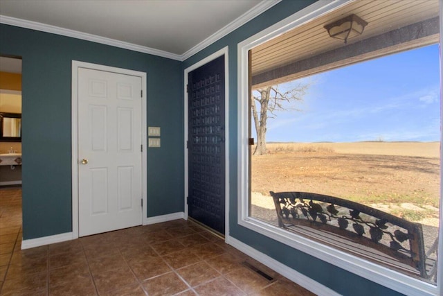 entrance foyer with crown molding, dark tile patterned flooring, visible vents, and baseboards