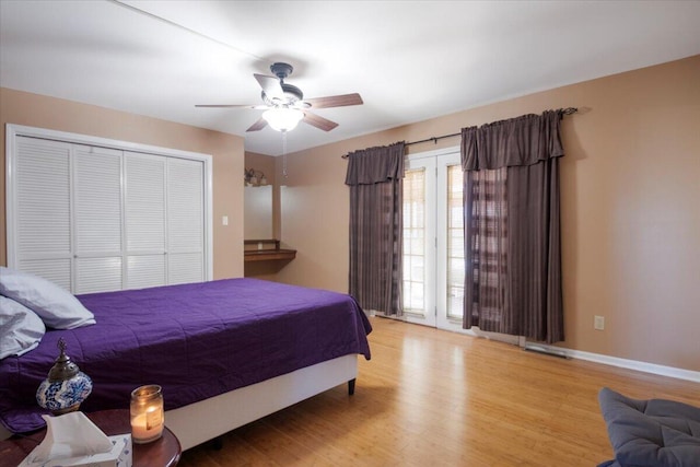 bedroom featuring a ceiling fan, wood finished floors, a closet, and baseboards