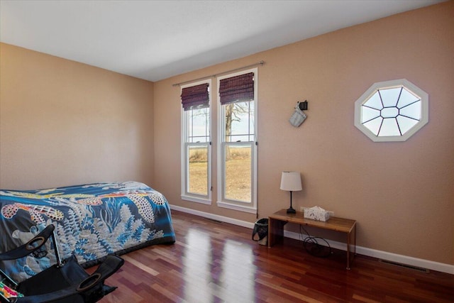 bedroom featuring visible vents, wood finished floors, and baseboards