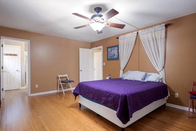 bedroom with baseboards, wood finished floors, and a ceiling fan