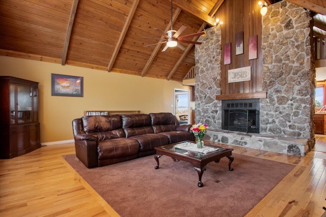 living area with wood ceiling, high vaulted ceiling, a stone fireplace, and wood finished floors