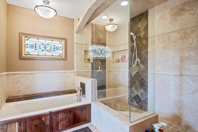 bathroom featuring a tile shower and a bath