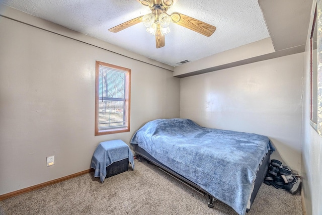 carpeted bedroom with a ceiling fan, baseboards, visible vents, and a textured ceiling