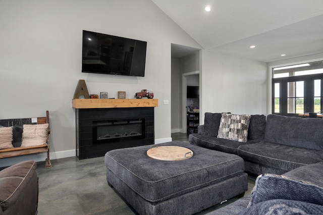 living area featuring finished concrete flooring, baseboards, a glass covered fireplace, high vaulted ceiling, and recessed lighting