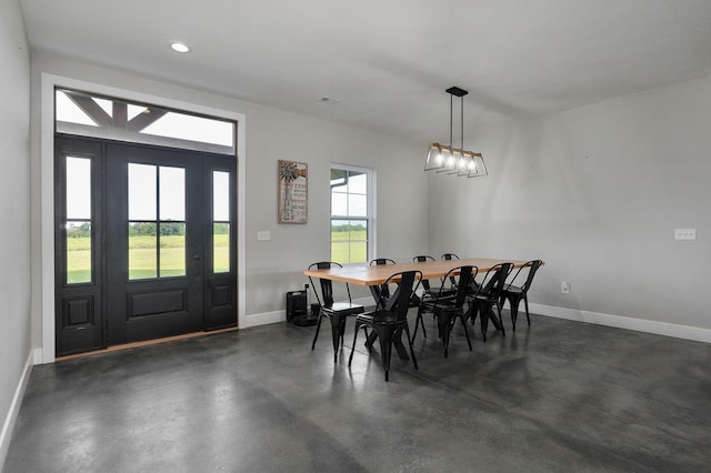 dining room with concrete flooring, recessed lighting, and baseboards