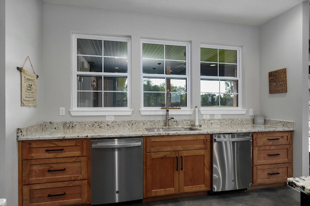 kitchen with a sink, light stone countertops, brown cabinets, and dishwasher