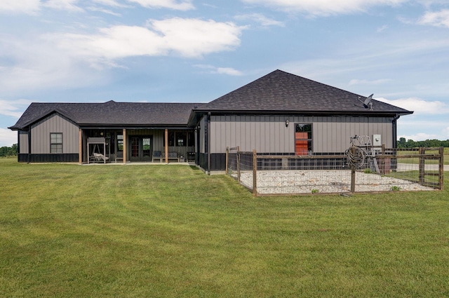 back of house with a shingled roof, an outdoor structure, board and batten siding, and an exterior structure