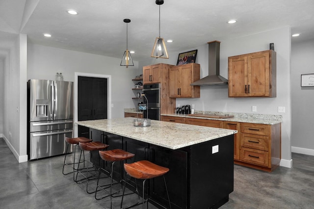 kitchen featuring stainless steel appliances, brown cabinetry, concrete flooring, and wall chimney exhaust hood