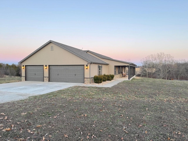 view of front of house with a garage, stone siding, concrete driveway, and a front yard