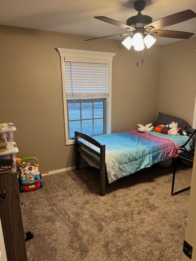 carpeted bedroom with a ceiling fan and baseboards