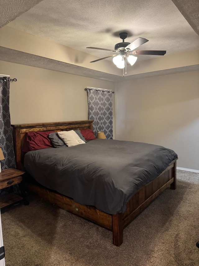 carpeted bedroom with ceiling fan and a textured ceiling