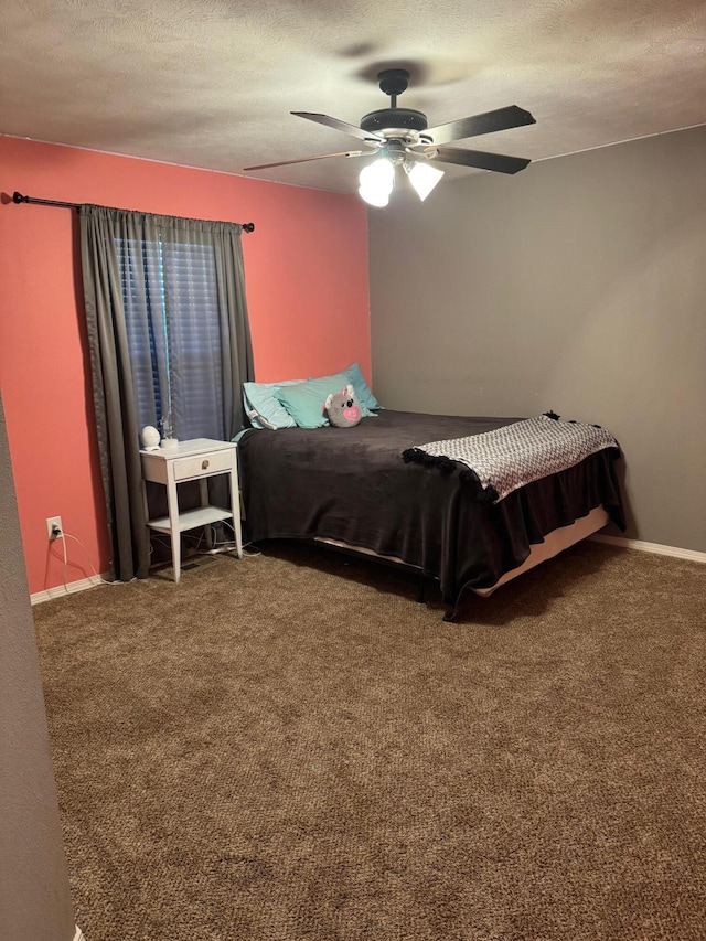 carpeted bedroom with ceiling fan, baseboards, and a textured ceiling