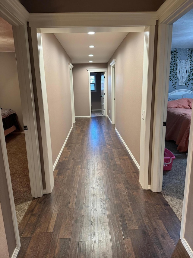 hallway with recessed lighting, dark wood-style flooring, and baseboards