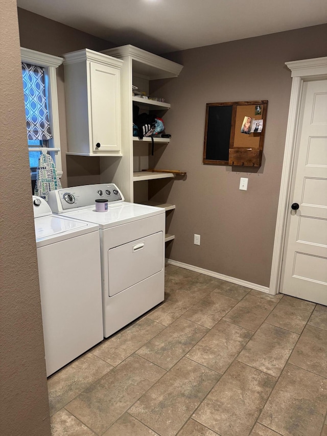 laundry room with cabinet space, baseboards, and washer and clothes dryer