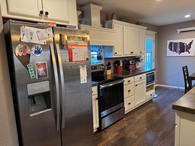 kitchen with stainless steel appliances, dark countertops, white cabinetry, and dark wood-style floors