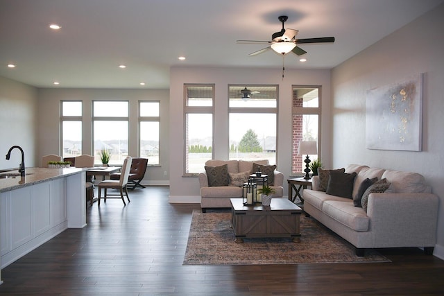 living room featuring baseboards, dark wood-type flooring, a ceiling fan, and recessed lighting