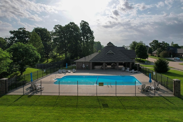 pool with a lawn, a patio, and fence