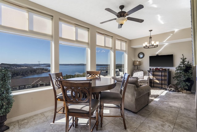 tiled dining space with ceiling fan with notable chandelier and baseboards