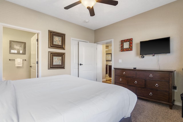 carpeted bedroom with ensuite bathroom, ceiling fan, a closet, and baseboards