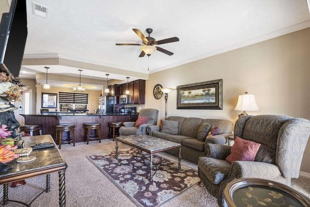 living area with a ceiling fan, light colored carpet, ornamental molding, and visible vents