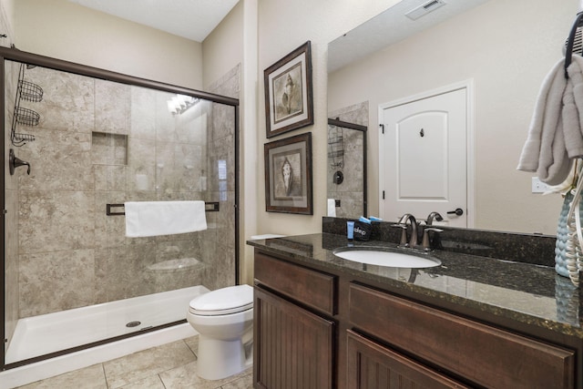 bathroom with visible vents, toilet, tile patterned flooring, vanity, and a shower stall