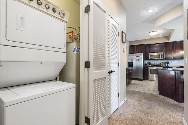 laundry room with light carpet, laundry area, light tile patterned floors, stacked washer and clothes dryer, and a textured ceiling