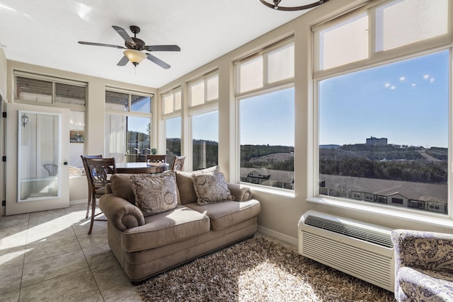 sunroom with a wall unit AC and ceiling fan