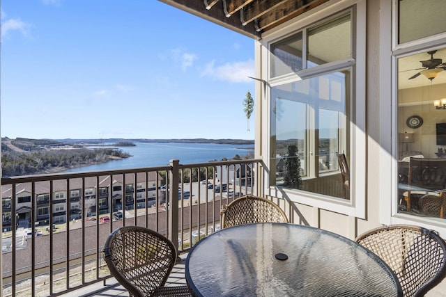 balcony with a water view and outdoor dining space