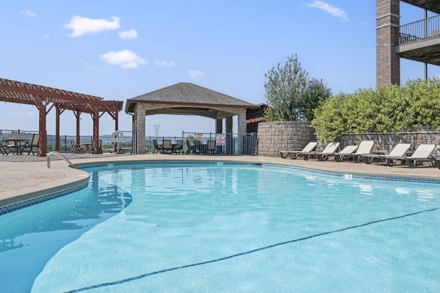 community pool with fence, a pergola, and a patio