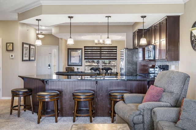 kitchen featuring light carpet, open floor plan, dark brown cabinets, appliances with stainless steel finishes, and dark countertops