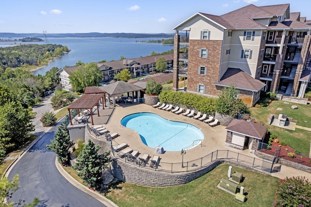 view of pool featuring a water view, fence, and a gazebo