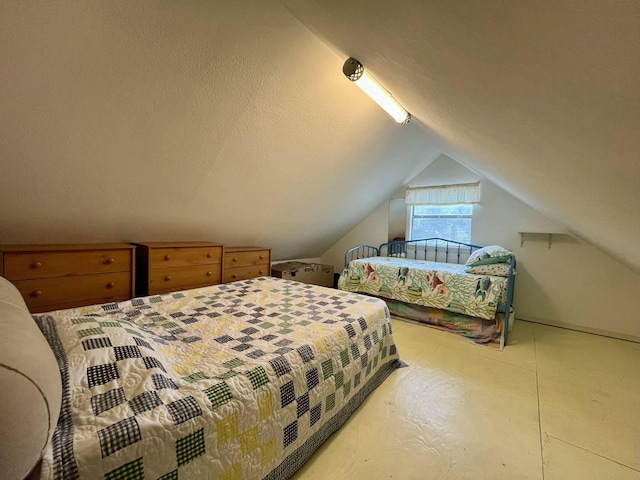 bedroom with vaulted ceiling and a textured ceiling