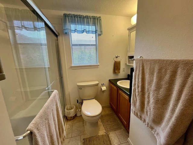 bathroom with toilet, tile patterned flooring, a textured ceiling, vanity, and a shower stall