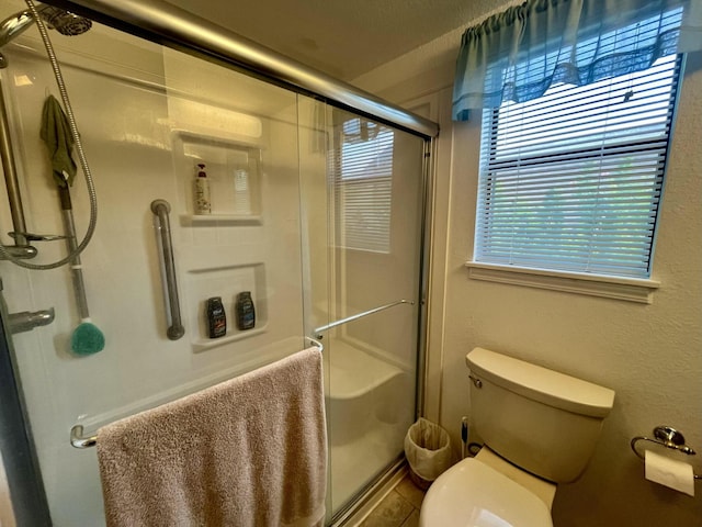 full bathroom with a stall shower and toilet