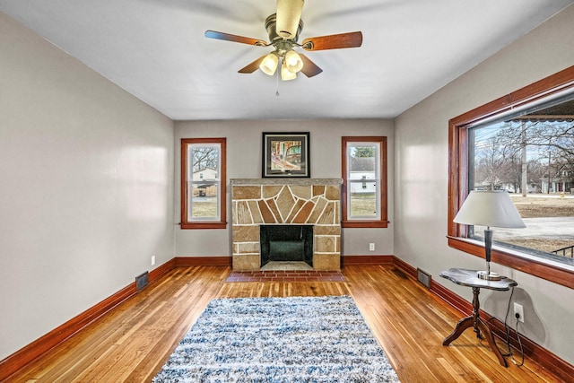 sitting room with baseboards, a fireplace, and light wood-style floors