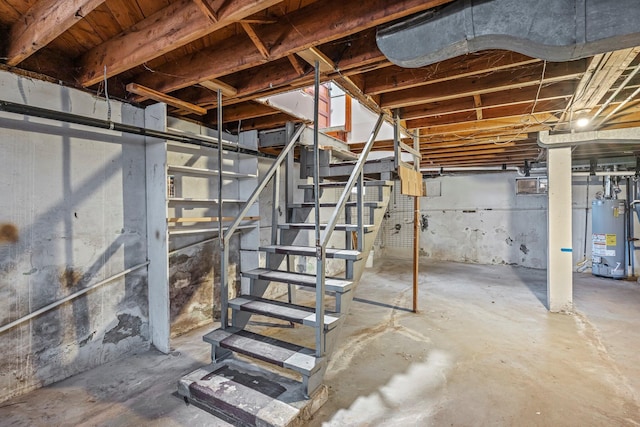 unfinished below grade area with stairs and gas water heater