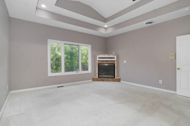 unfurnished living room with visible vents, baseboards, a glass covered fireplace, lofted ceiling, and carpet