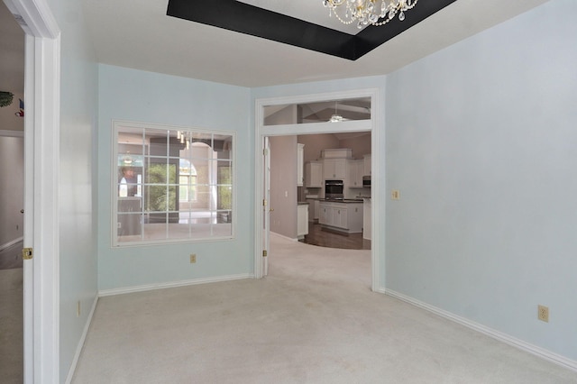 unfurnished room with baseboards, light colored carpet, and an inviting chandelier