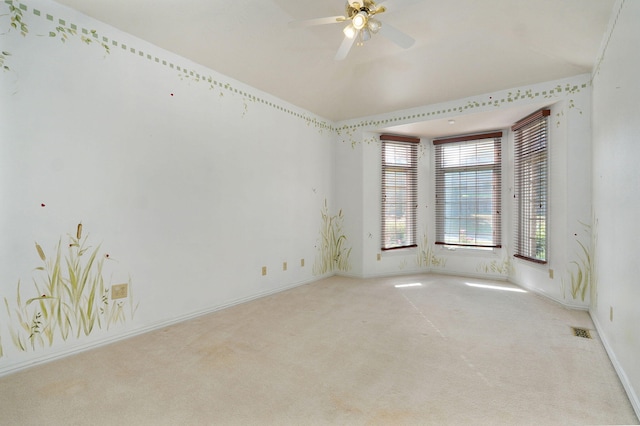 unfurnished room featuring ceiling fan, light colored carpet, visible vents, baseboards, and vaulted ceiling