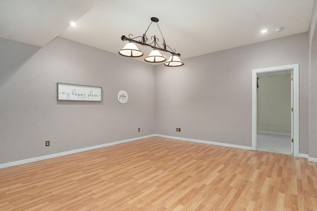 spare room featuring recessed lighting, baseboards, and light wood finished floors