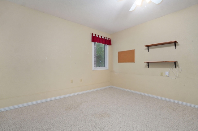 carpeted empty room featuring baseboards