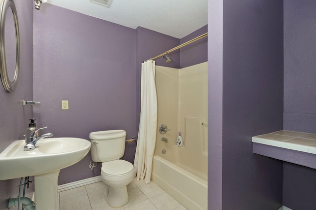 bathroom featuring toilet, visible vents, baseboards, tile patterned floors, and shower / bathtub combination with curtain