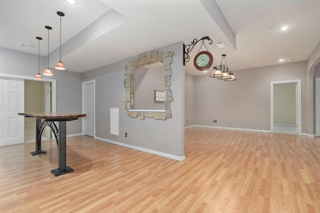 interior space featuring light wood-type flooring, baseboards, arched walkways, and recessed lighting